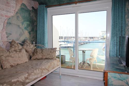 a living room with a couch and a large sliding glass door at Unique, loft-style apartment with fantastic Brighton Marina views in Brighton & Hove