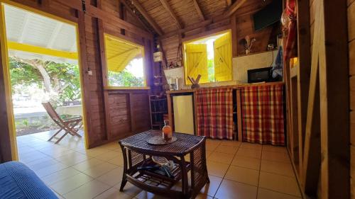 a kitchen with yellow cabinets and a table in a room at Bungalows du Soleil - Piscine Jardin Fleuri in Le Gosier