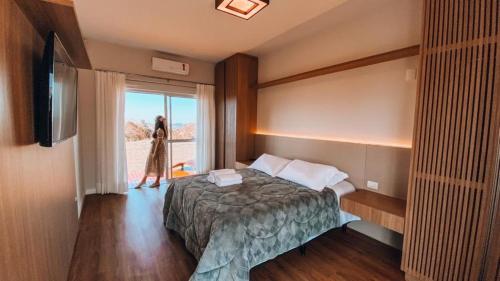 a hotel room with a bed and a window at Casa Paraíso do Sol - Rancho Queimado - SC in Rancho Queimado