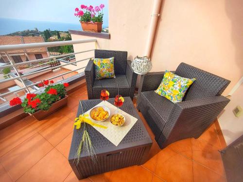 - un balcon avec 2 chaises et une table avec de la nourriture dans l'établissement Casa vacanze Magabù, à Cefalù