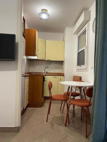 - une cuisine avec une table, des chaises et une table dans l'établissement 2/3 pièces avec terrasse à NICE, à Nice