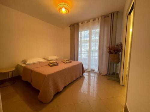 - une chambre avec un lit et une grande fenêtre dans l'établissement 2/3 pièces avec terrasse à NICE, à Nice