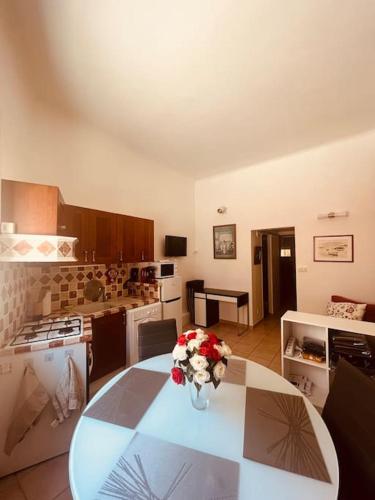 une cuisine avec une table avec un vase de fleurs dessus dans l'établissement Le Bremond, à Cassis