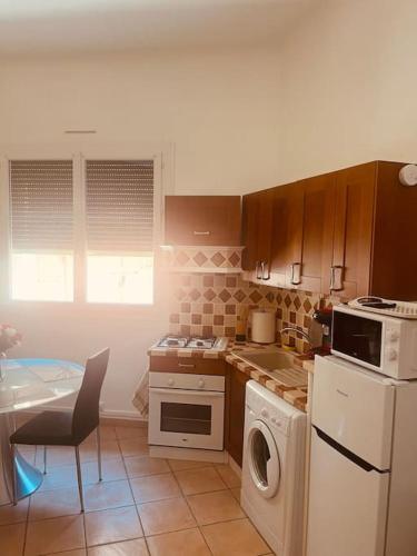 une cuisine avec un lave-linge et un lave-vaisselle dans l'établissement Le Bremond, à Cassis