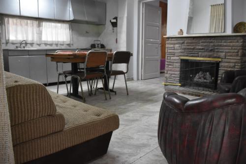 sala de estar con sofá y chimenea en Complejo Los Platanos en General Alvear