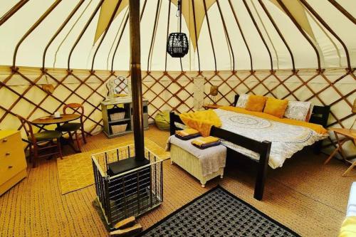 um quarto com uma cama e um fogão numa tenda em Bronfelen Yurt em Cynghordy