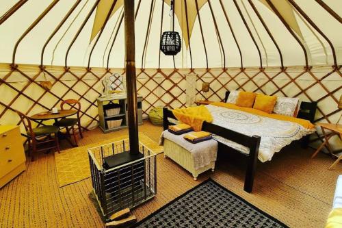 a room with a bed and a stove in a yurt at Bronfelen Yurt in Cynghordy