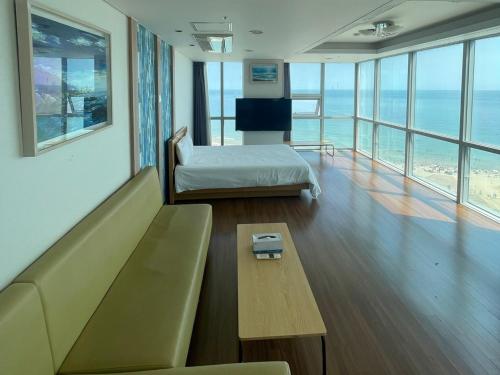 a room with a couch and a bed and a table at Elysia Boutique Hotel in Busan