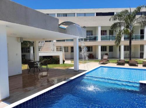 グアラジュバにあるBella casa 10 em Guarajuba, apartamento equipado para você e sua família, tudo que você precisa pra se sentir em casa!の建物の前のプール