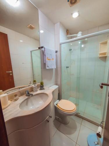 a bathroom with a toilet and a sink and a shower at Bella casa 10 em Guarajuba, apartamento equipado para você e sua família, tudo que você precisa pra se sentir em casa! in Guarajuba