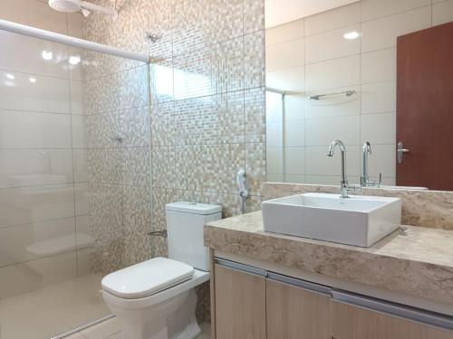 a bathroom with a toilet and a sink and a shower at Casa de férias do Sonho in Santa Cruz Cabrália