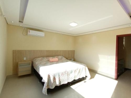 a bedroom with a bed with a white blanket at Casa de férias do Sonho in Santa Cruz Cabrália