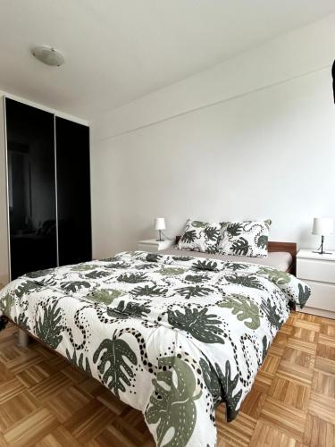 Un dormitorio con una cama con un edredón blanco y negro. en Apartma Lunca 1, en Liubliana