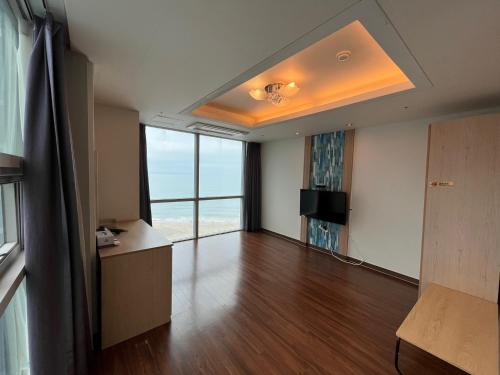 an empty living room with a view of the ocean at Elysia Boutique Hotel in Busan
