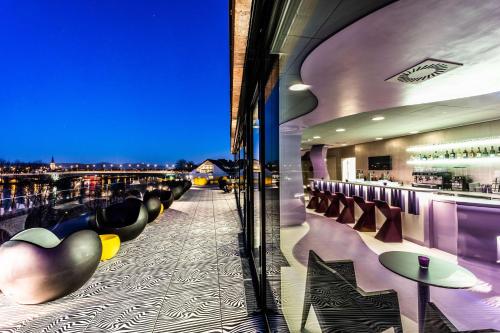 a bar with a view of a city at night at Prize by Radisson, Bonn City in Bonn
