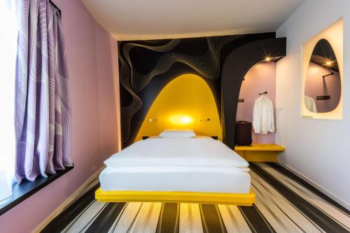 a bedroom with a bed and a painting on the wall at Prize by Radisson, Bonn City in Bonn
