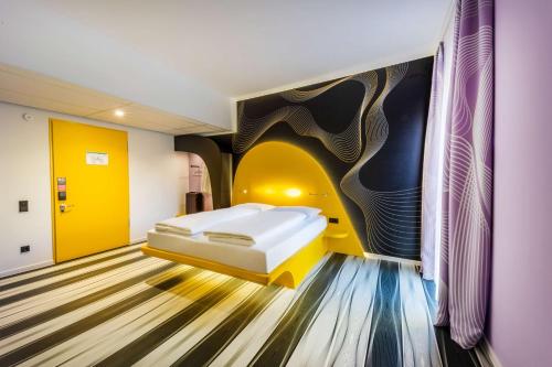 Zimmer mit einem Bett und einem Wandgemälde in der Unterkunft prizeotel Bonn-City in Bonn