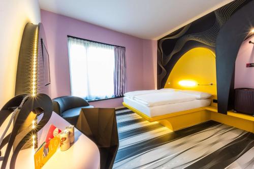a hotel room with a bed and a table at Prize by Radisson, Bonn City in Bonn