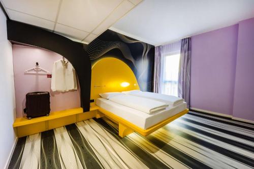 ein Schlafzimmer mit einem Bett in einem Zimmer mit lila Wänden in der Unterkunft prizeotel Bonn-City in Bonn