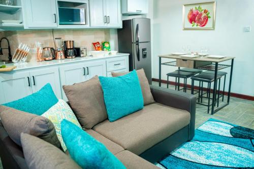 a living room with a couch and a kitchen at Escappé Suites 