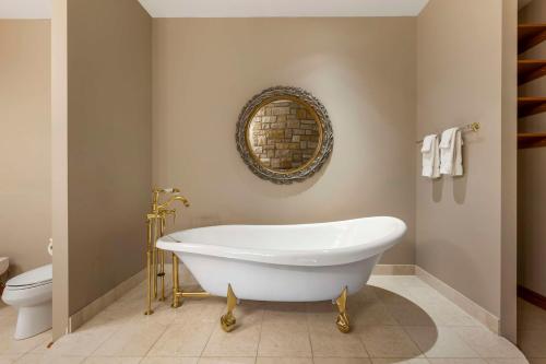 a white bath tub in a bathroom with a toilet at Christie's Mill Inn & Spa - BW Premier Collection in Port Severn