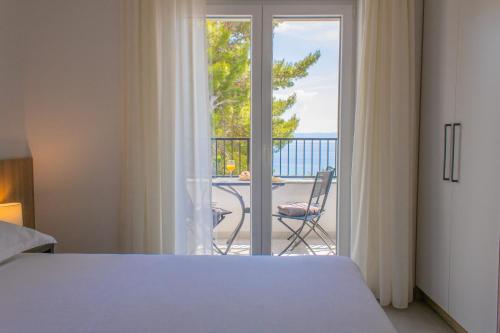 a bedroom with a bed and a view of a balcony at Apartments Maris in Baška Voda
