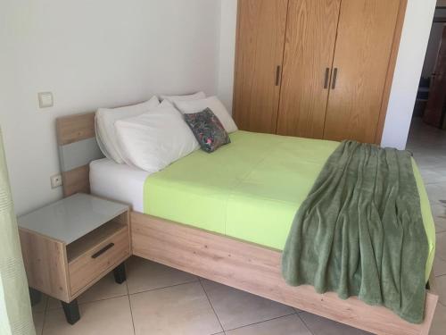 a bed with a wooden frame and a night stand at Beralmar Asilah Chez FATIMA in Asilah