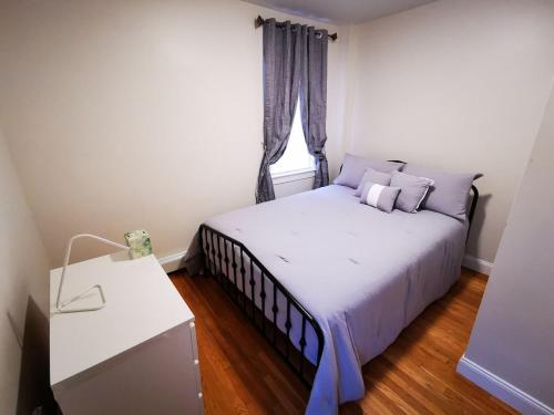 um pequeno quarto com uma cama e uma janela em Location+Comfort+Convenience em Boston