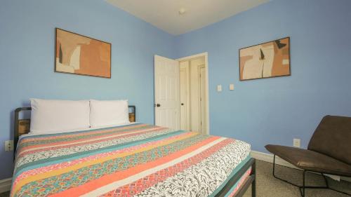ein blaues Schlafzimmer mit einem Bett und einem Stuhl in der Unterkunft Atlantic Suite by the Boardwalk 2C in Atlantic City