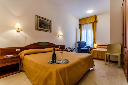 a hotel room with two beds and a table with a bottle of wine at Cannaregio II Apartments in Venice