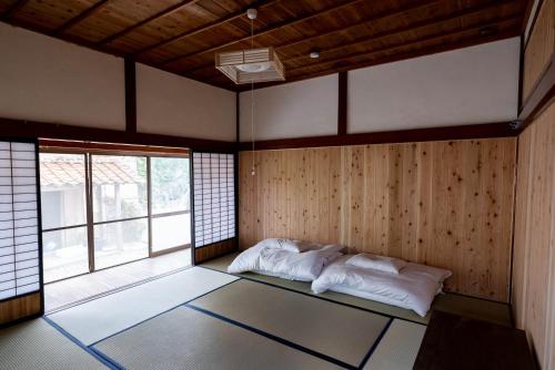 Habitación con cama en habitación con ventana en guesthouse碧, en Okinoshima