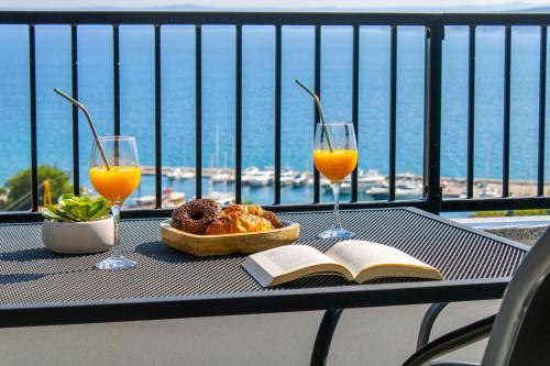 a table with a book and two glasses of orange juice at Apartments Maris in Baška Voda