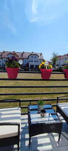 a patio with a table and chairs and some flowers at 4 Foxes in Ustka