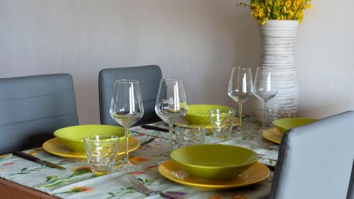 a table with plates and wine glasses on it at La Terrazza In Centro Dorgali in Dorgali