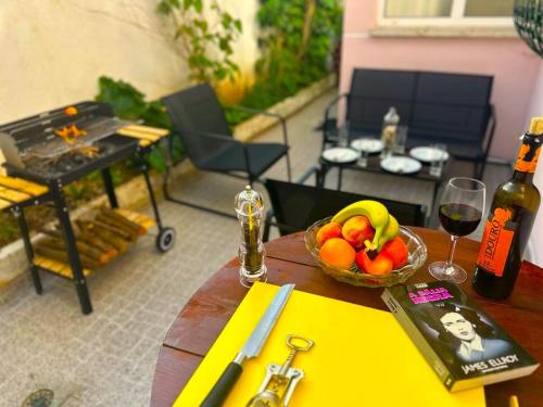 un tavolo con un cesto di frutta e una bottiglia di vino di LISABONNA GUEST HOUSE a Lisbona