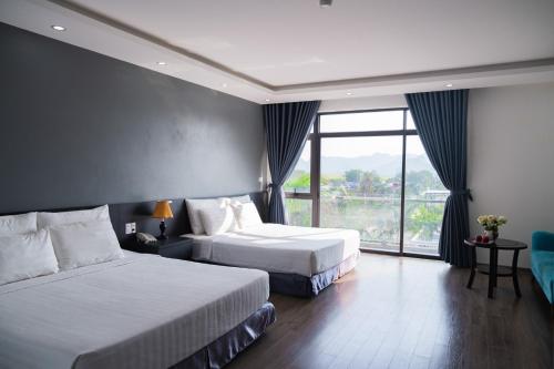 a hotel room with two beds and a large window at Ninh Bình Premier hotel in Ninh Binh