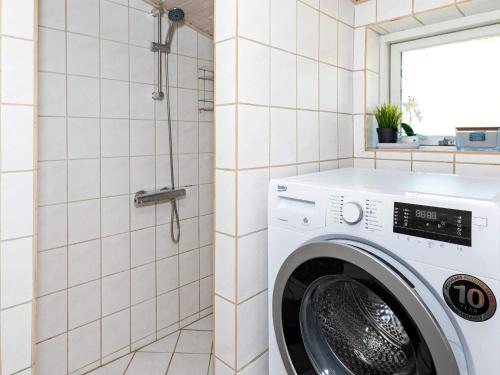 a white washing machine in a bathroom with a shower at 4 person holiday home in Hals-By Traum in Hals