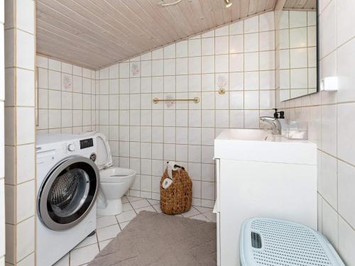 a bathroom with a washing machine and a toilet at 4 person holiday home in Hals-By Traum in Hals