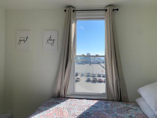 a bedroom with a window with a view of a parking lot at The Oakden Suites - Orange Loop D6 in Atlantic City