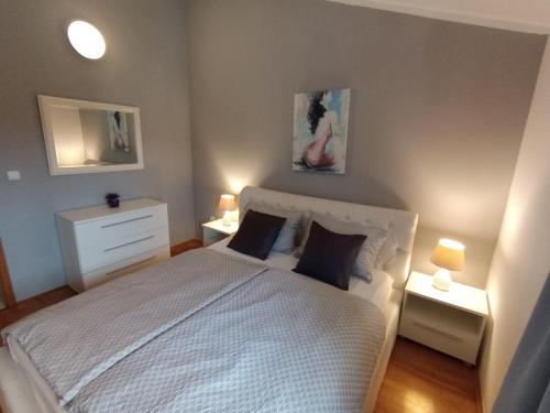 a bedroom with a white bed and two lamps at Apartment Anita in Umag