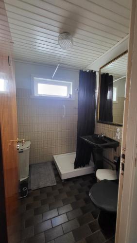a bathroom with a shower and a toilet and a sink at Heart of the City (Hotel Bólið Guesthouse) in Tórshavn