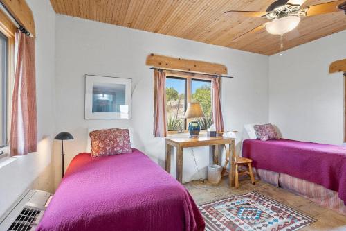 a bedroom with two beds and a table with a window at Casa de Luna in Alpine