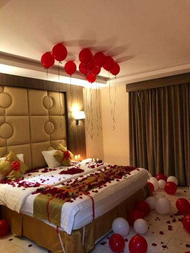 um quarto com uma cama com balões vermelhos pendurados no tecto em منازل الساهر للوحدات المخدومة فرع 2 em Al Qunfudhah