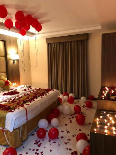 um quarto com uma cama com balões vermelhos e brancos no chão em منازل الساهر للوحدات المخدومة فرع 2 em Al Qunfudhah