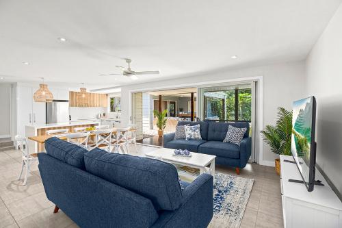 a living room with two blue couches and a kitchen at North Beach in Mylestom