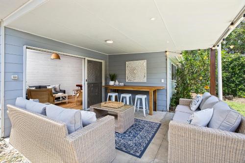 a patio with wicker chairs and a table at North Beach in Mylestom