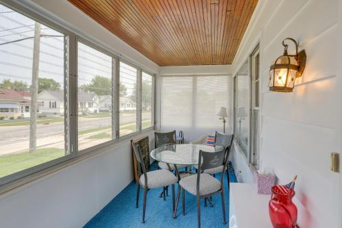 a porch with a table and chairs and windows at Home with Screened-In Porch Less Than 1 Mi to Lake Erie in Port Clinton