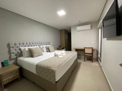 ein Schlafzimmer mit einem großen Bett und einem TV in der Unterkunft Hotel Conviver in Formosa