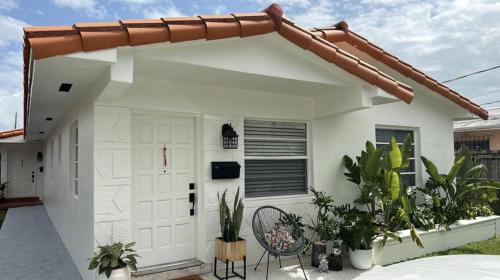 a white garage with a door and some plants at Miami's Cozy Tropical Getaway in Miami