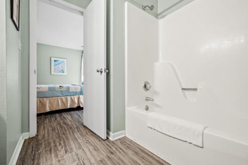 a bathroom with a tub and a bed in a room at Colony by the Sea #201 in Indian Beach